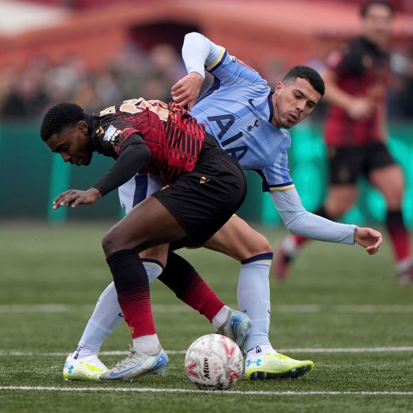 Tamworth's Beck-Ray Enoru, left, and Tottenham Hotspur's Pedro Porro battle for the ball during the English FA Cup third round match at The Lamb Ground, Tamworth, England, Sunday Jan. 12, 2025. (Joe Giddens/PA via AP)