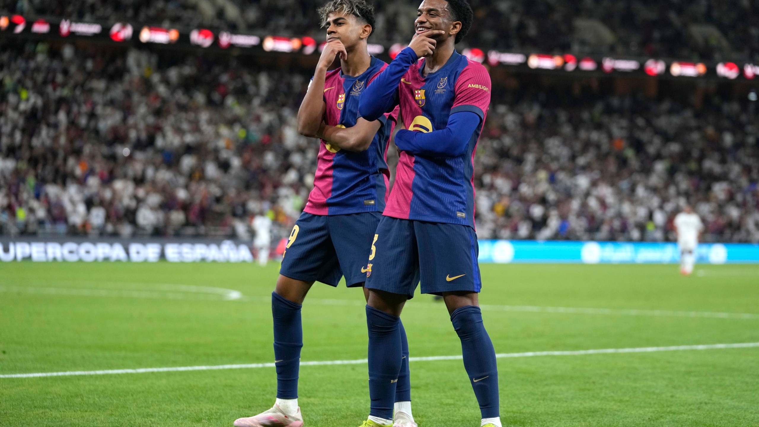 Barcelona's Alejandro Balde, right, and Barcelona's Lamine Yamal react during the Spain Super Cup final soccer match between Real Madrid and Barcelona at King Abdullah Stadium in Jeddah, Saudi Arabia, Sunday, Jan. 12, 2025. (AP Photo/Altaf Qadri)