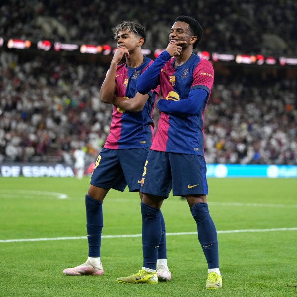 Barcelona's Alejandro Balde, right, and Barcelona's Lamine Yamal react during the Spain Super Cup final soccer match between Real Madrid and Barcelona at King Abdullah Stadium in Jeddah, Saudi Arabia, Sunday, Jan. 12, 2025. (AP Photo/Altaf Qadri)