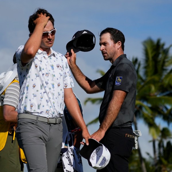 Nico Echavarria, left, of Columbia, walks away as Nick Taylor, of Canada, celebrates after winning their playoff in the final round of the Sony Open golf event, Sunday, Jan. 12, 2025, at Waialae Country Club in Honolulu. (AP Photo/Matt York)