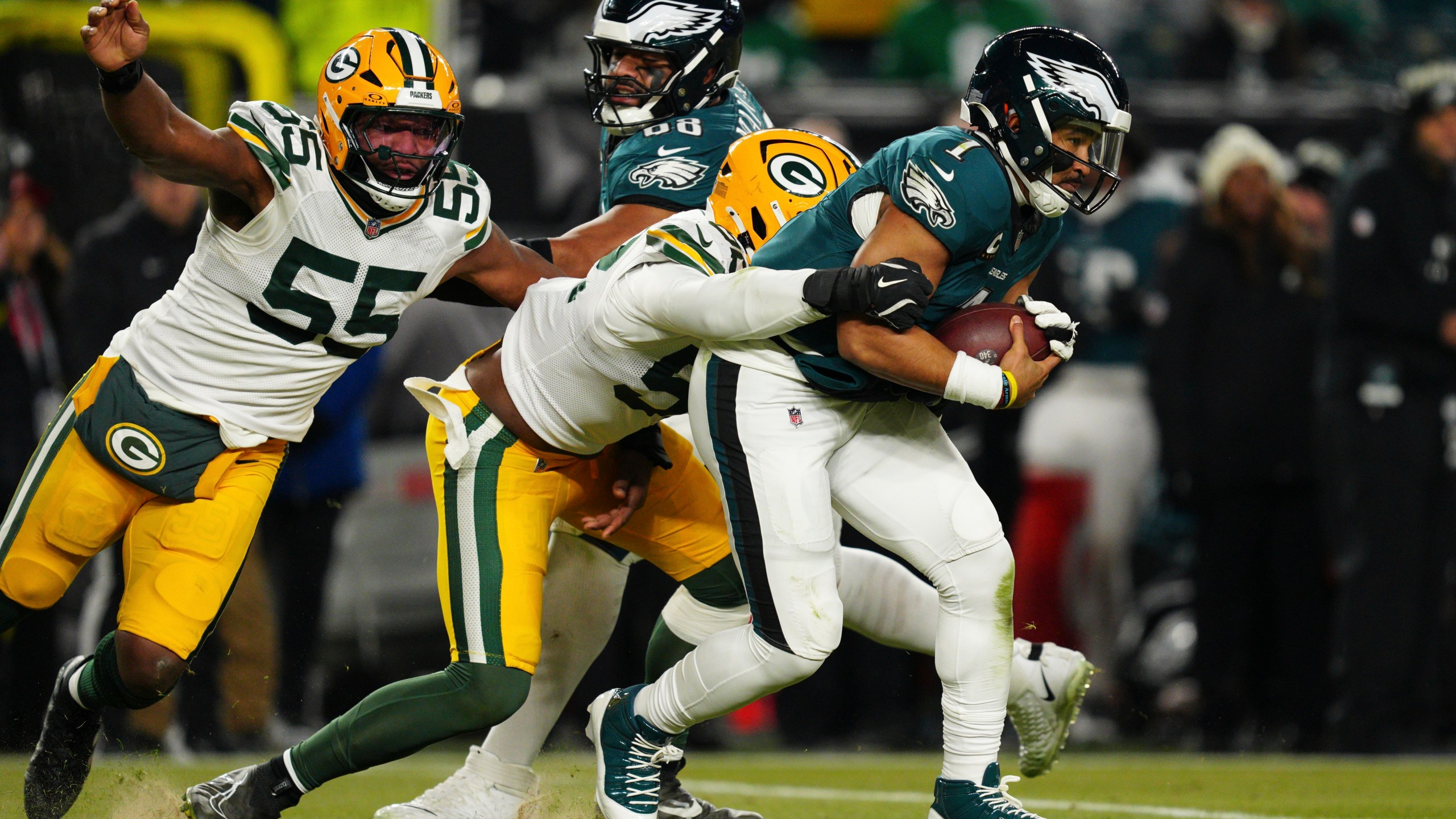 Philadelphia Eagles quarterback Jalen Hurts (1) is sacked by Green Bay Packers defensive end Rashan Gary (52) as Green Bay Packers defensive end Kingsley Enagbare (55) narrows in during the second half of an NFL wild-card playoff football game Sunday, Jan. 12, 2025, in Philadelphia. (AP Photo/Derik Hamilton)