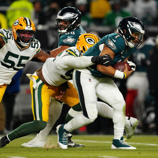 Philadelphia Eagles quarterback Jalen Hurts (1) is sacked by Green Bay Packers defensive end Rashan Gary (52) as Green Bay Packers defensive end Kingsley Enagbare (55) narrows in during the second half of an NFL wild-card playoff football game Sunday, Jan. 12, 2025, in Philadelphia. (AP Photo/Derik Hamilton)