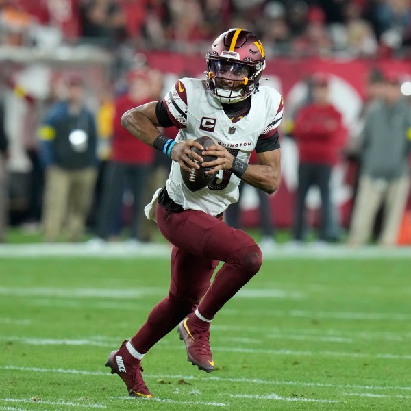 Washington Commanders quarterback Jayden Daniels (5) scrambles out of the pocket against the Tampa Bay Buccaneers during the first half of an NFL wild-card playoff football game in Tampa, Fla., Sunday, Jan. 12, 2025. (AP Photo/Chris O'Meara)