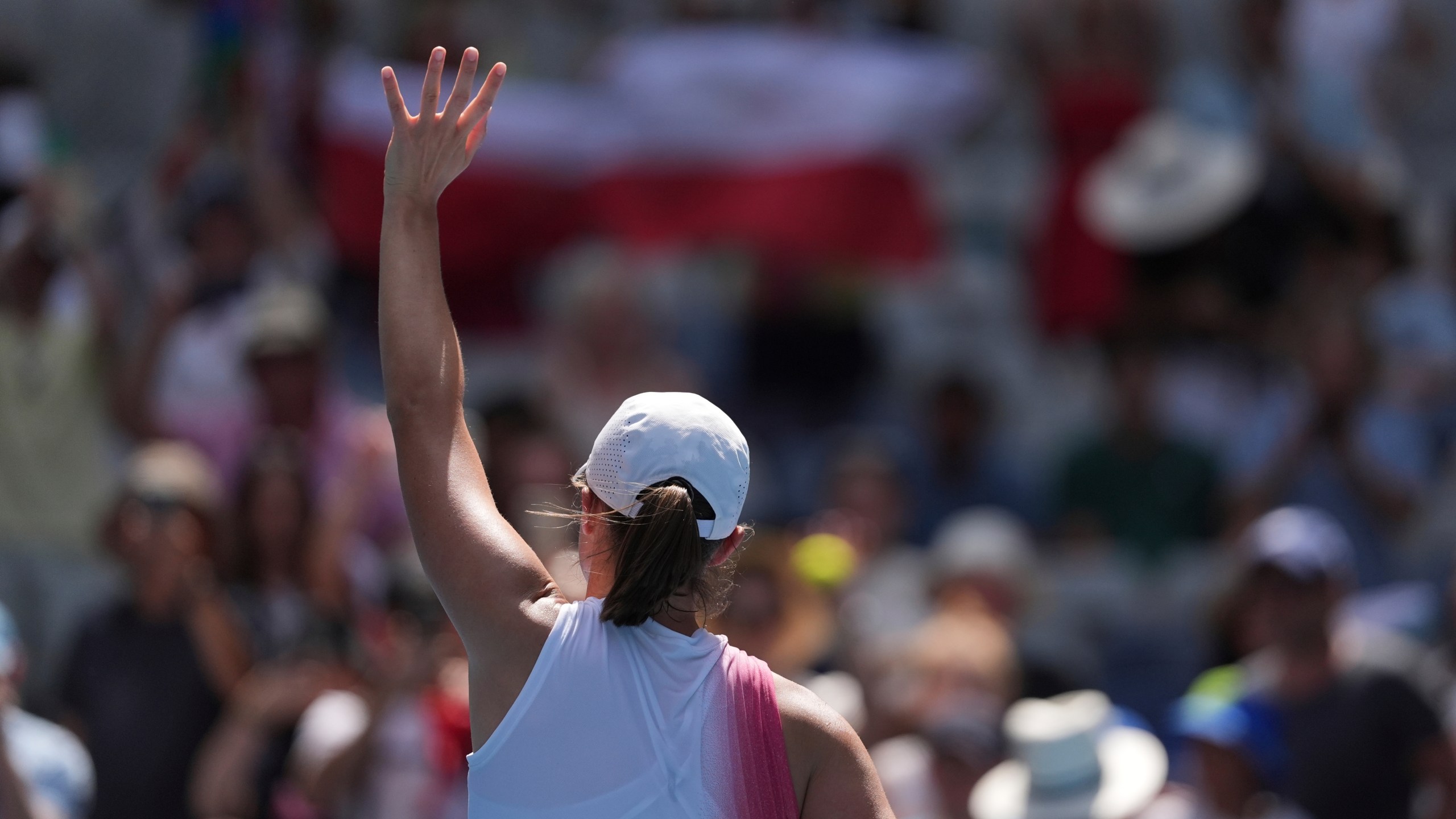 Iga Swiatek of Poland waves after defeating Katerina Siniakova of the Czech Republic in their first round match at the Australian Open tennis championship in Melbourne, Australia, Monday, Jan. 13, 2025. (AP Photo/Ng Han Guan)