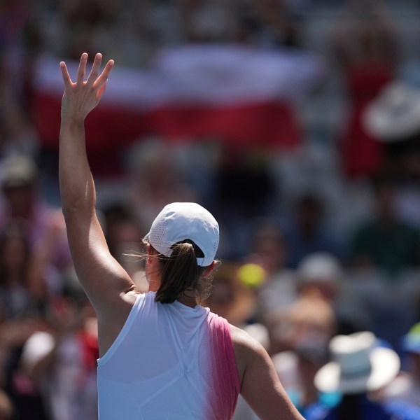 Iga Swiatek of Poland waves after defeating Katerina Siniakova of the Czech Republic in their first round match at the Australian Open tennis championship in Melbourne, Australia, Monday, Jan. 13, 2025. (AP Photo/Ng Han Guan)