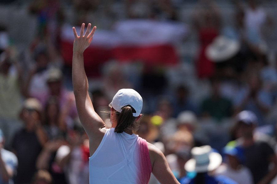 Iga Swiatek of Poland waves after defeating Katerina Siniakova of the Czech Republic in their first round match at the Australian Open tennis championship in Melbourne, Australia, Monday, Jan. 13, 2025. (AP Photo/Ng Han Guan)