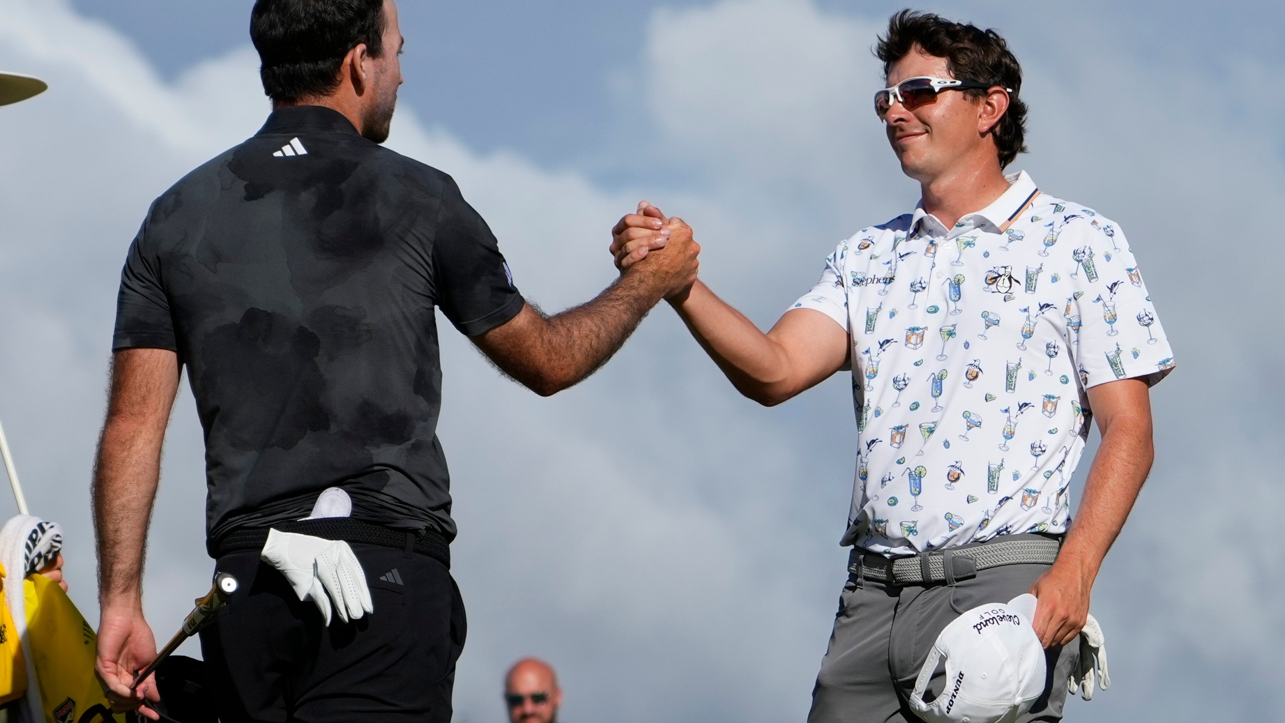 Nick Taylor, left, of Canada, is greeted by Nico Echavarria, of Columbia, after winning their playoff during the final round of the Sony Open golf event, Sunday, Jan. 12, 2025, at Waialae Country Club in Honolulu. (AP Photo/Matt York)