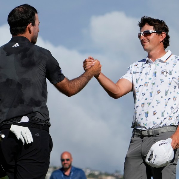 Nick Taylor, left, of Canada, is greeted by Nico Echavarria, of Columbia, after winning their playoff during the final round of the Sony Open golf event, Sunday, Jan. 12, 2025, at Waialae Country Club in Honolulu. (AP Photo/Matt York)