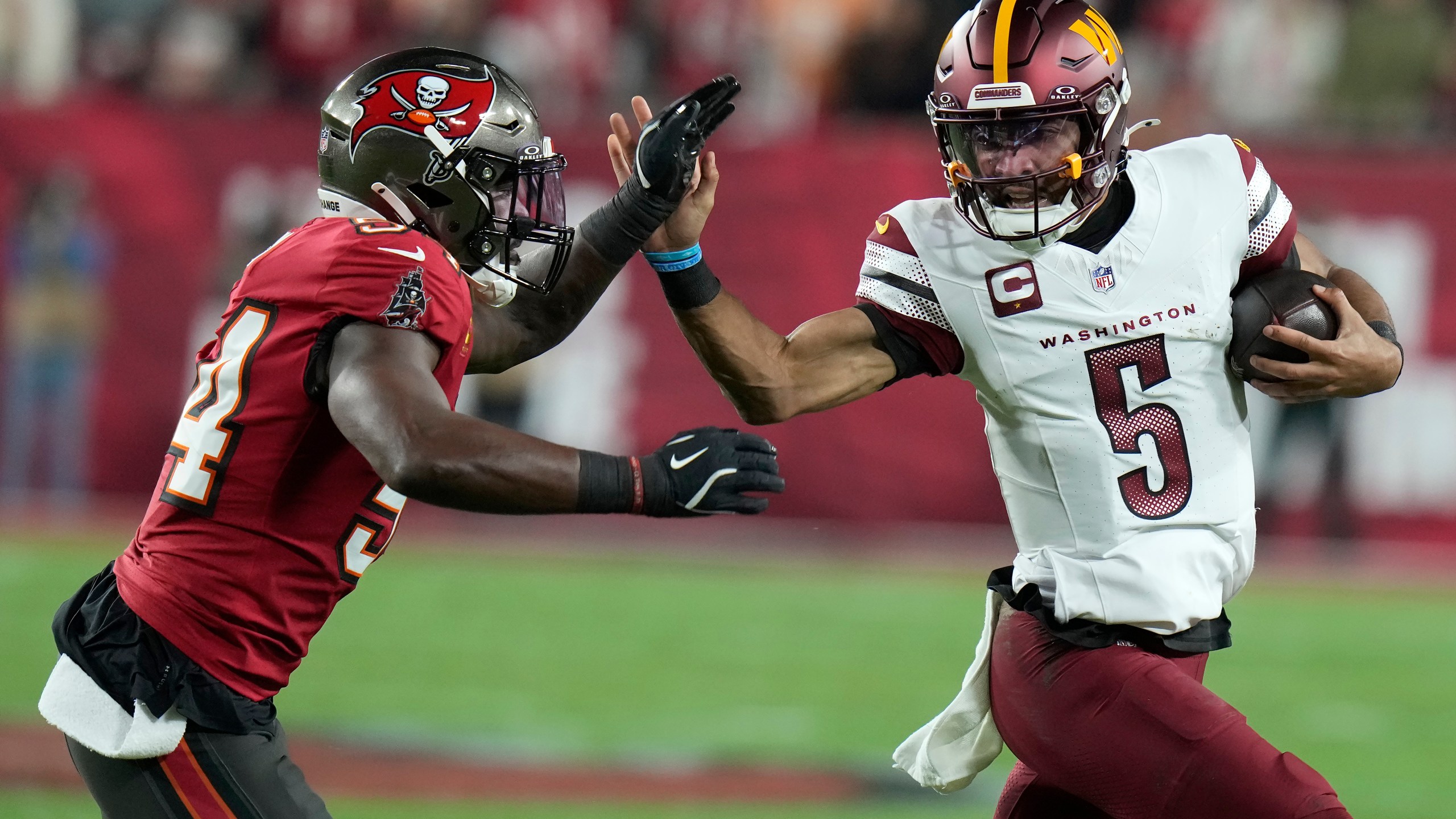 Tampa Bay Buccaneers linebacker Lavonte David, left, forces Washington Commanders quarterback Jayden Daniels (5) out of bounds during the first half of an NFL wild-card playoff football game in Tampa, Fla., Sunday, Jan. 12, 2025. (AP Photo/Chris O'Meara)