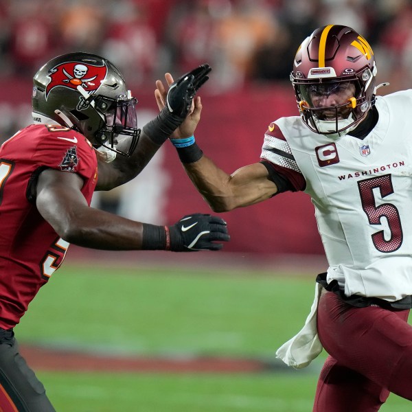 Tampa Bay Buccaneers linebacker Lavonte David, left, forces Washington Commanders quarterback Jayden Daniels (5) out of bounds during the first half of an NFL wild-card playoff football game in Tampa, Fla., Sunday, Jan. 12, 2025. (AP Photo/Chris O'Meara)