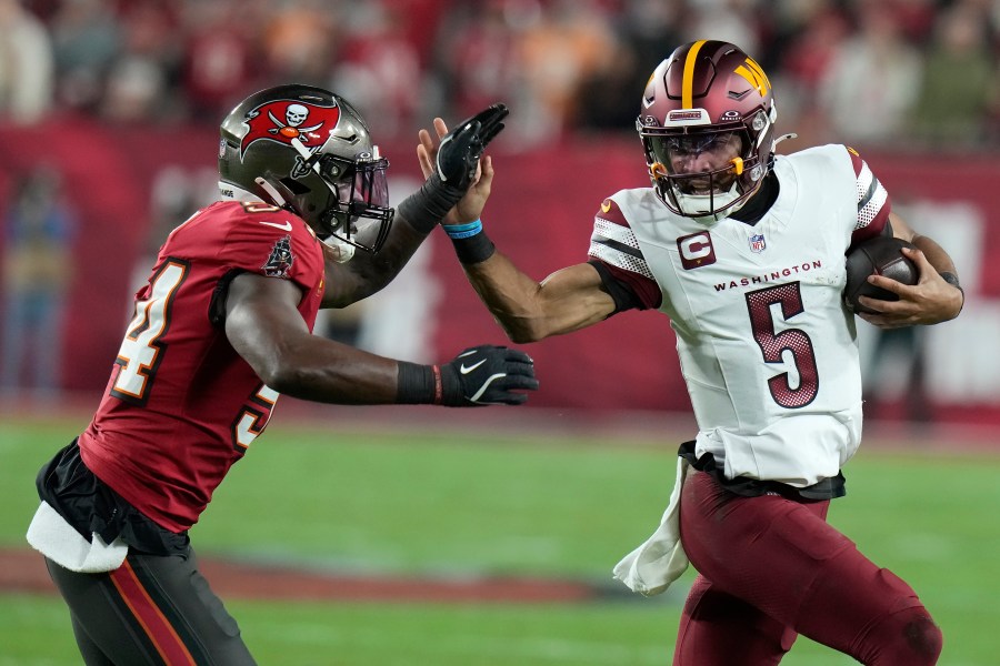 Tampa Bay Buccaneers linebacker Lavonte David, left, forces Washington Commanders quarterback Jayden Daniels (5) out of bounds during the first half of an NFL wild-card playoff football game in Tampa, Fla., Sunday, Jan. 12, 2025. (AP Photo/Chris O'Meara)