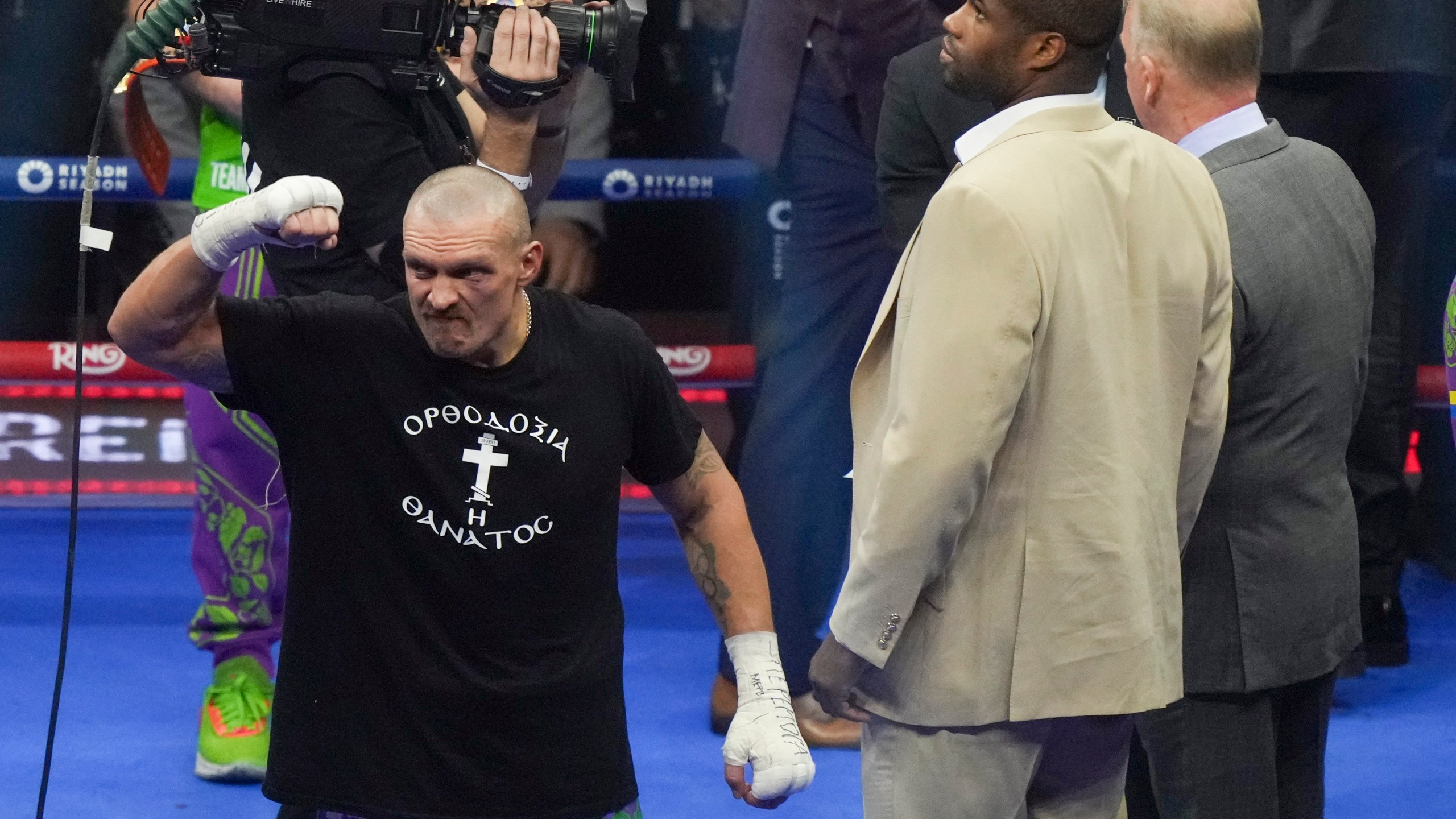 Ukraine's Oleksandr Usyk, left, celebrates alongside fellow boxer Daniel Dubois after winning the WBA, WBO, and WBC world heavyweight title fight against Britain's Tyson Fury in Riyadh, Saudi Arabia, Sunday, Dec. 22, 2024. (AP Photo/Frank Augstein)