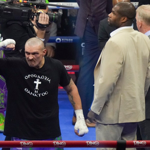 Ukraine's Oleksandr Usyk, left, celebrates alongside fellow boxer Daniel Dubois after winning the WBA, WBO, and WBC world heavyweight title fight against Britain's Tyson Fury in Riyadh, Saudi Arabia, Sunday, Dec. 22, 2024. (AP Photo/Frank Augstein)