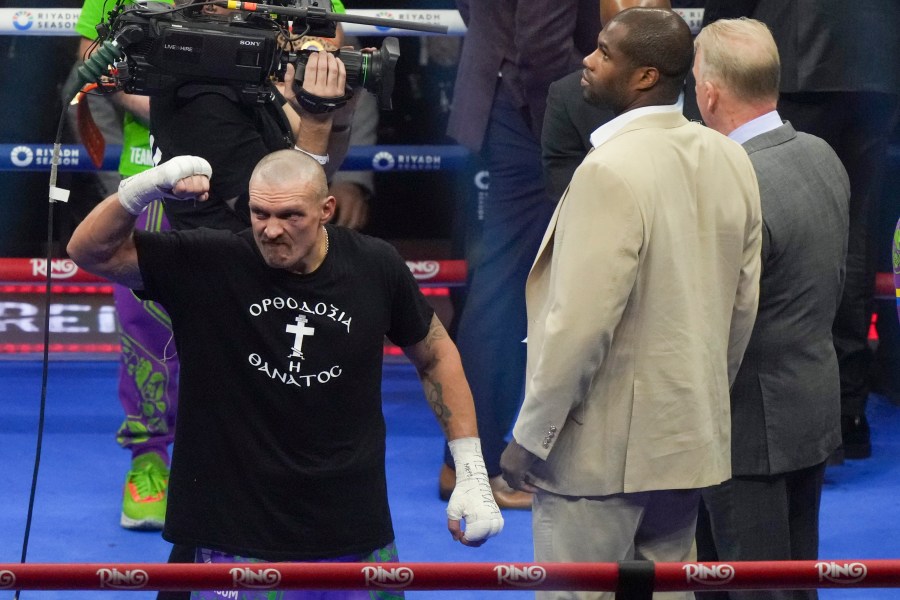 Ukraine's Oleksandr Usyk, left, celebrates alongside fellow boxer Daniel Dubois after winning the WBA, WBO, and WBC world heavyweight title fight against Britain's Tyson Fury in Riyadh, Saudi Arabia, Sunday, Dec. 22, 2024. (AP Photo/Frank Augstein)