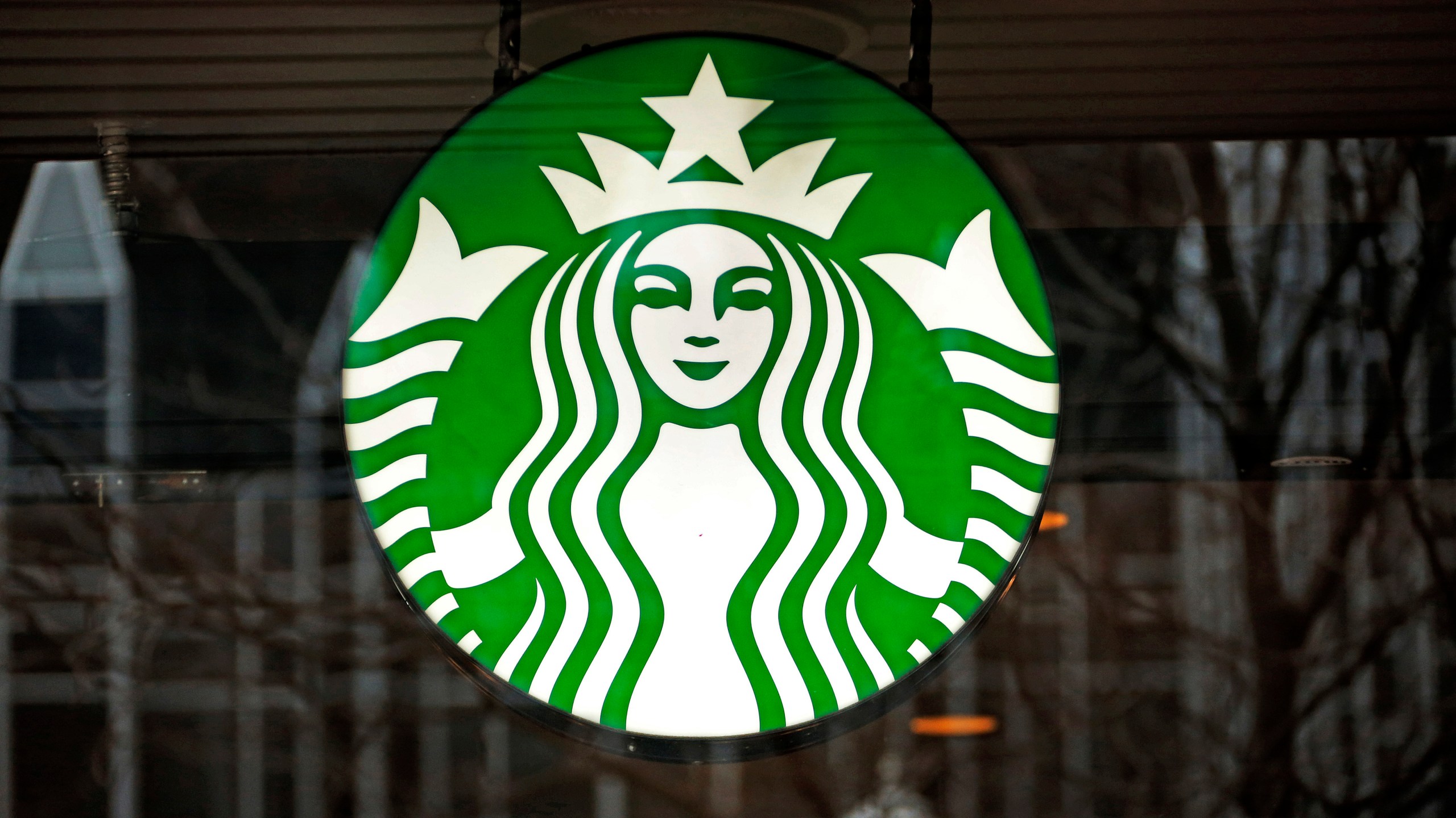 FILE - A Starbucks logo sign in the window of one of the chain's cafes in Pittsburgh, Jan. 12, 2017. (AP Photo/Gene J. Puskar, File)