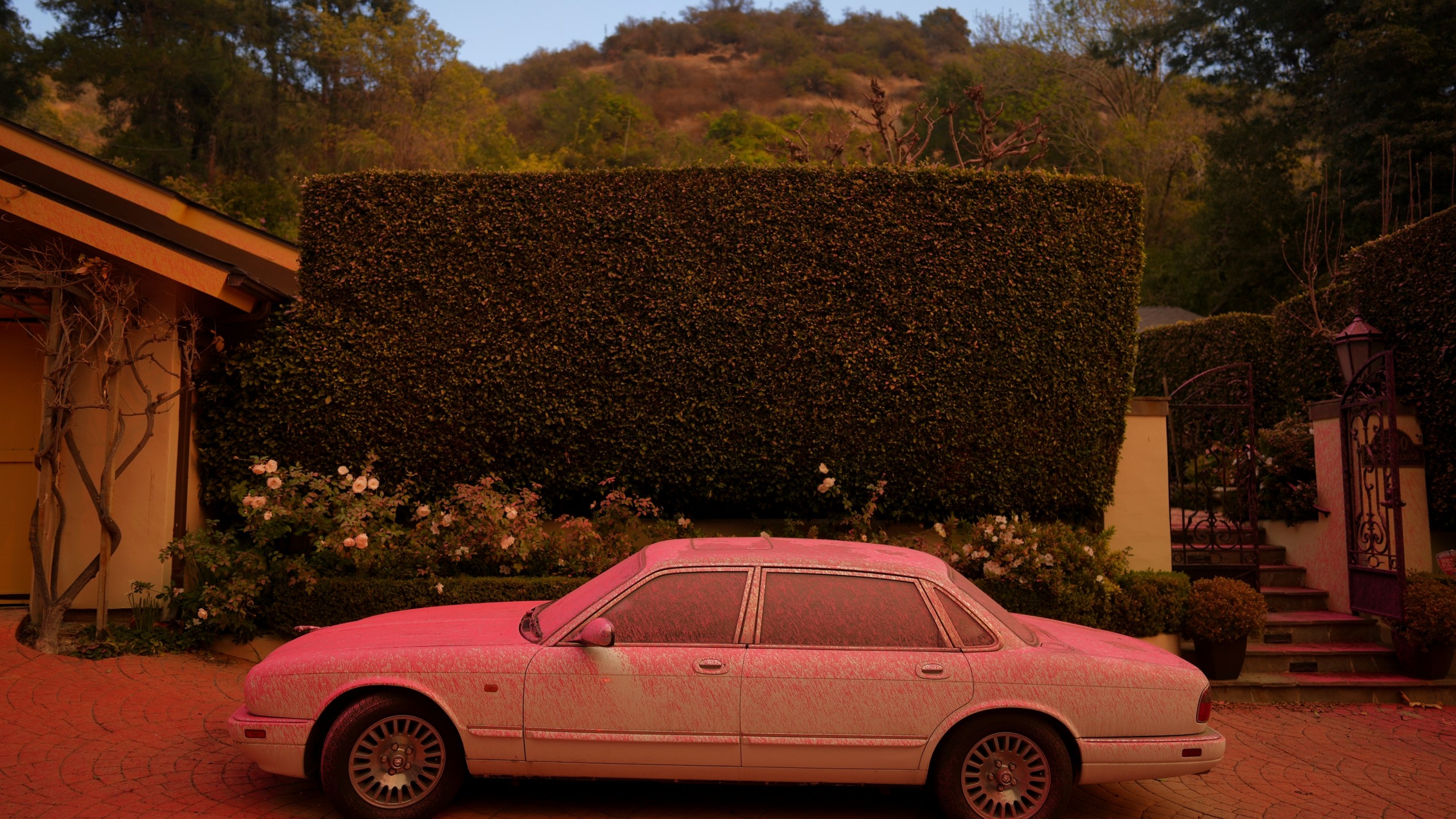 FILE - A vehicle is covered in fire retardant while crews battle the Palisades Fire in Mandeville Canyon on Jan. 11, 2025, in Los Angeles. (AP Photo/Eric Thayer, File)