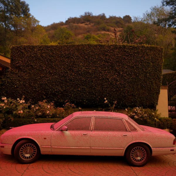 FILE - A vehicle is covered in fire retardant while crews battle the Palisades Fire in Mandeville Canyon on Jan. 11, 2025, in Los Angeles. (AP Photo/Eric Thayer, File)