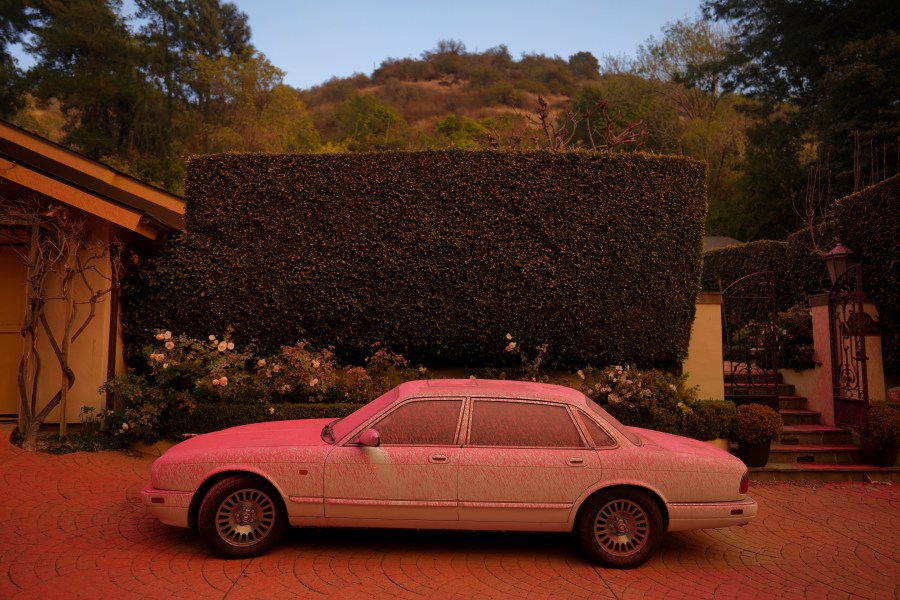 FILE - A vehicle is covered in fire retardant while crews battle the Palisades Fire in Mandeville Canyon on Jan. 11, 2025, in Los Angeles. (AP Photo/Eric Thayer, File)