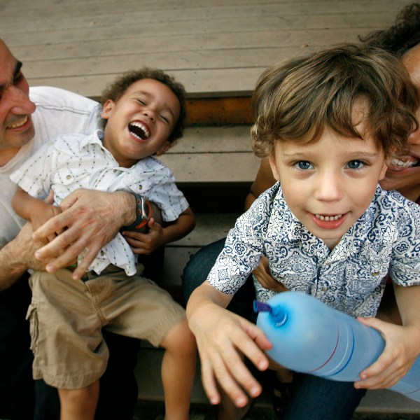 FILE - Alex Diaz-Asper, left, and his wife Rachel Lerman, far right, play with their twin boys, Alejandro, center left, and Miguel , 3, at their home in Washington, June 11, 2008. (AP Photo/Jacquelyn Martin, File)