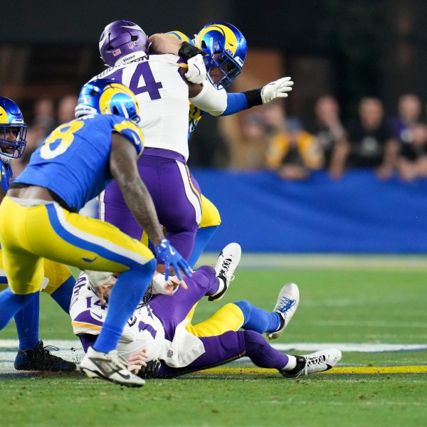 Los Angeles Rams linebacker Jared Verse (8) looks to pick up a Minnesota Vikings quarterback Sam Darnold (14) fumble caused by Ahkello Witherspoon (4) during the first half of an NFL wild card playoff football game, Monday, Jan. 13, 2025, in Glendale, Ariz.Verse returned the fumble for a 57-yard touchdown. (AP Photo/Ross D. Franklin)