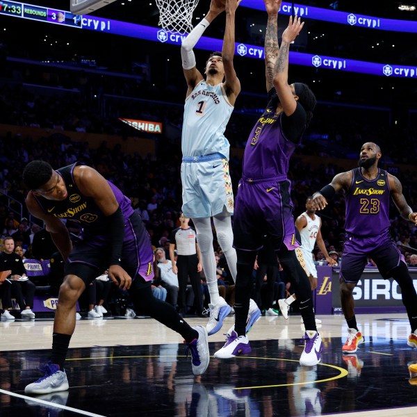 San Antonio Spurs center Victor Wembanyama (1) goes up to score against Los Angeles Lakers forward Anthony Davis (3) during the first quarter of an NBA basketball game Monday, Jan. 13, 2025, in Los Angeles. (AP Photo/Kevork Djansezian)