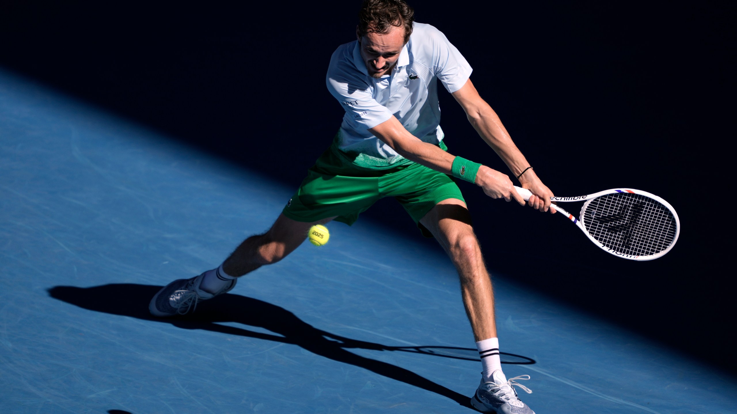 Daniil Medvedev of Russia plays a backhand return to Kasidit Samrej of Thailand during their first round match at the Australian Open tennis championship in Melbourne, Australia, Tuesday, Jan. 14, 2025. (AP Photo/Ng Han Guan)