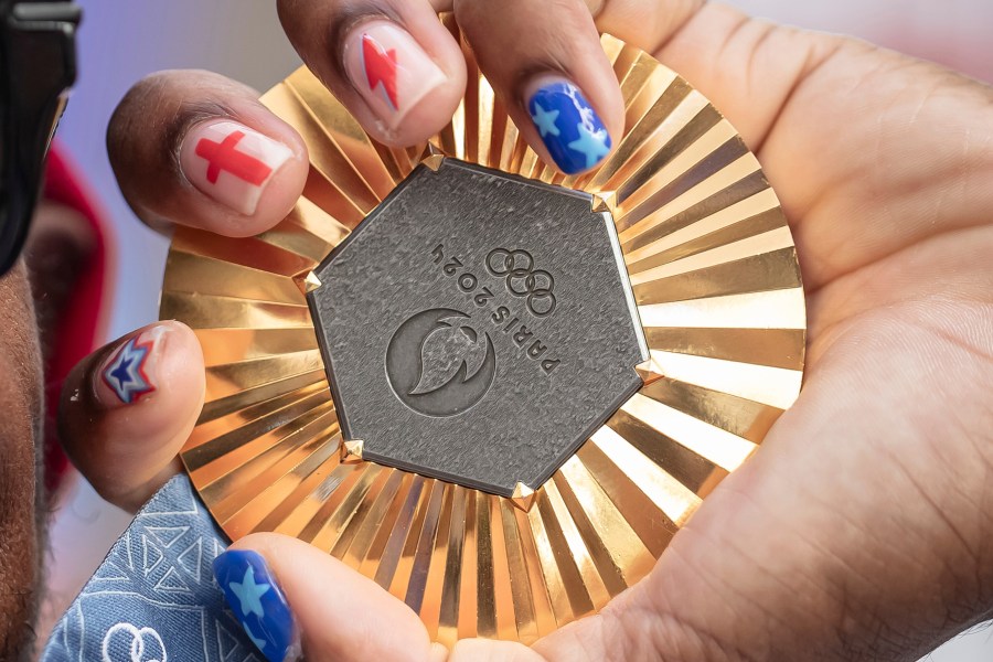 FILE - American Olympic champion Noah Lyles holds this gold medal before an interview in Paris, France, Sunday, Aug. 11, 2024. (AP Photo/Aurelien Morissard, File)