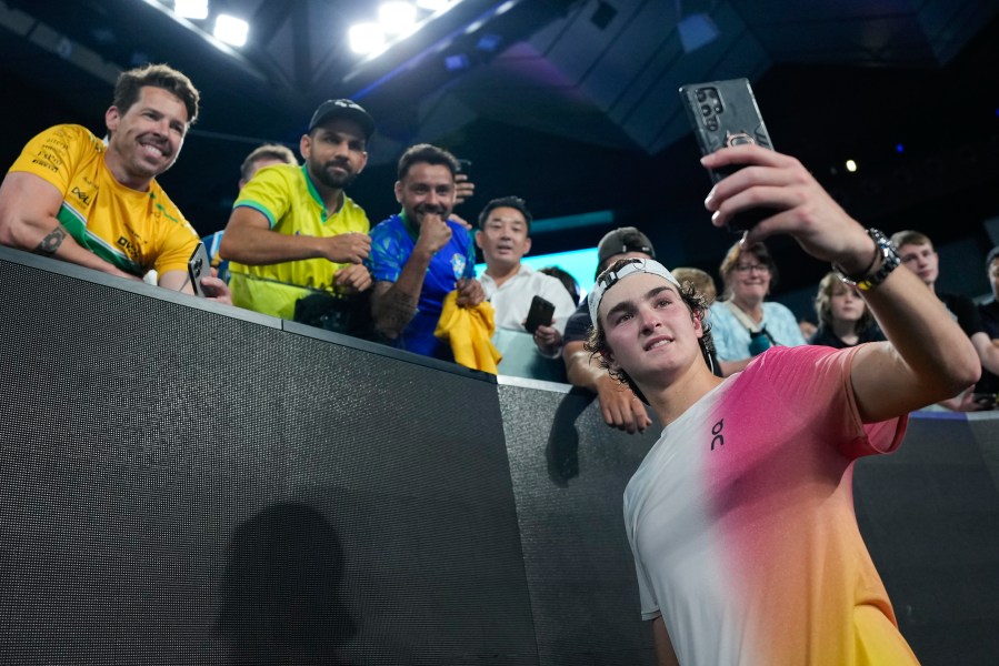 Joao Fonseca of Brazil takes a selfie with fans after defeating Andrey Rublev of Russia in their first round match at the Australian Open tennis championship in Melbourne, Australia, Tuesday, Jan. 14, 2025. (AP Photo/Asanka Brendon Ratnayake)