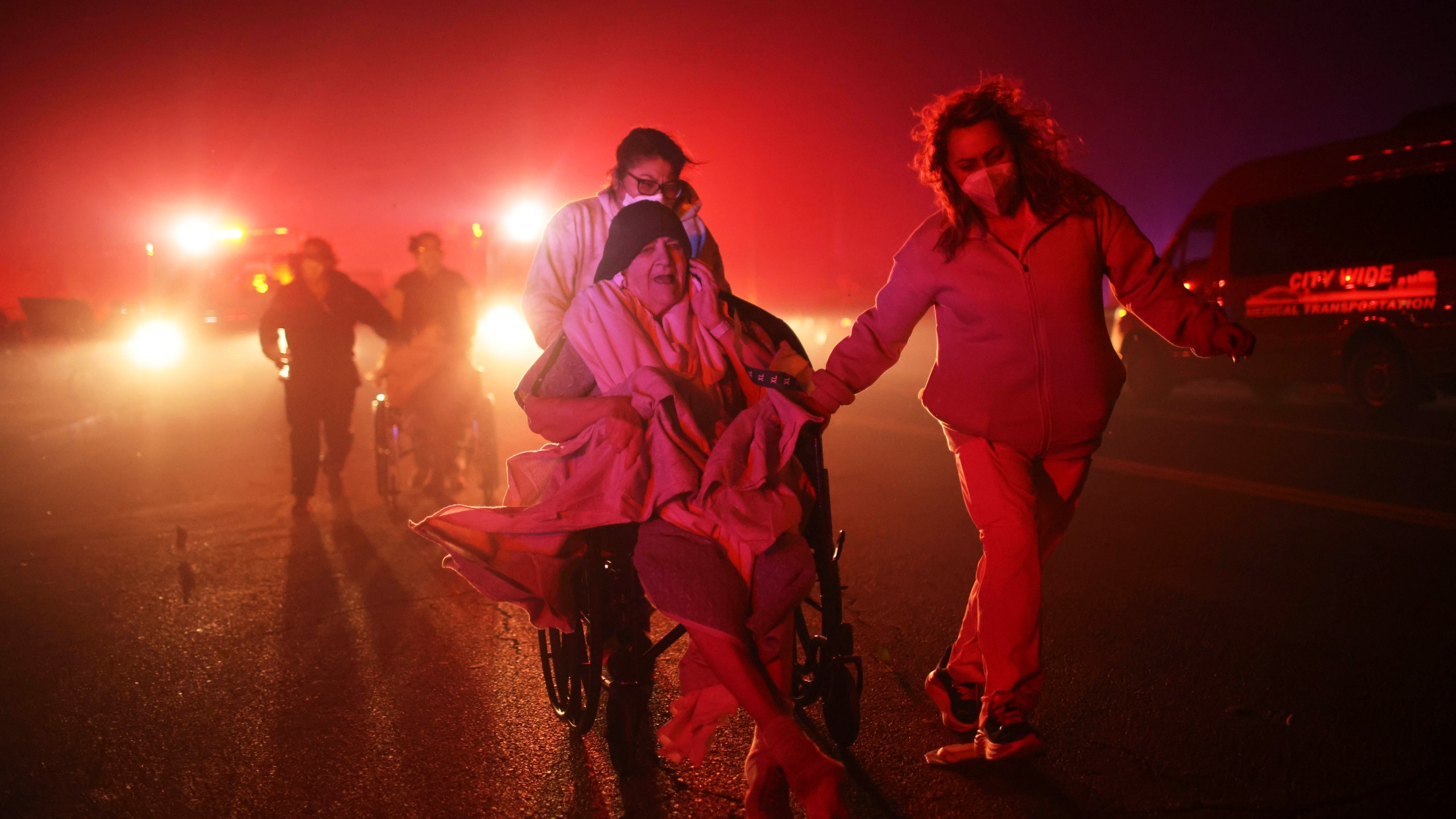 FILE - Residents and staff at Pasadena Park Healthcare & Wellness Center evacuate as the Eaton Fire approaches on Jan. 7, 2025, in Altadena, Calif. (AP Photo/Ethan Swope, File)