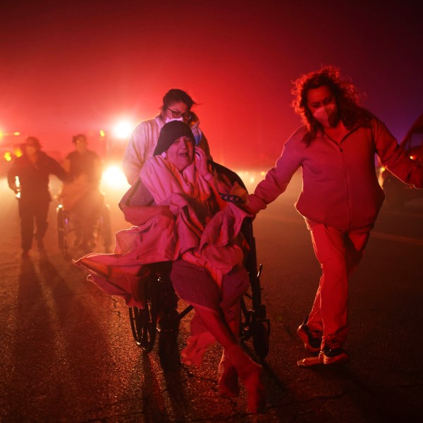 FILE - Residents and staff at Pasadena Park Healthcare & Wellness Center evacuate as the Eaton Fire approaches on Jan. 7, 2025, in Altadena, Calif. (AP Photo/Ethan Swope, File)