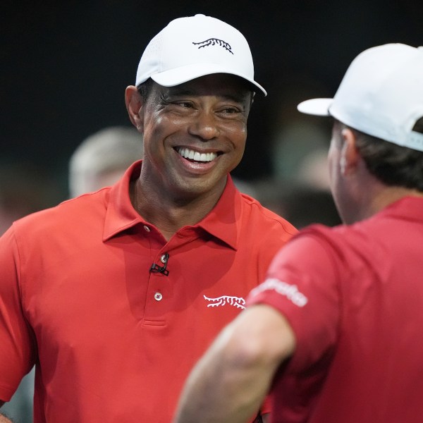 Tiger Woods talks to his Jupiter Links Golf Club teammate Kevin Kisner before the start of a match against the Los Angeles Golf Club, Tuesday, Jan. 14, 2025, in Palm Beach Gardens, Fla. TGL featured two teams of three players competing against each other in a tech-infused arena the size of a football field. (AP Photo/Marta Lavandier)