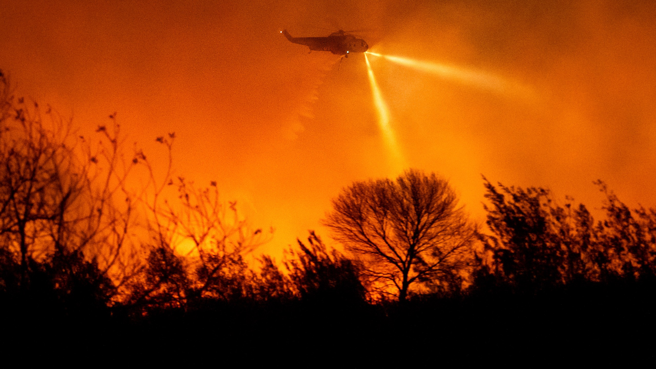 A helicopter drops water while fighting the Auto Fire in Ventura County, Calif., on Monday, Jan. 13, 2025. (AP Photo/Noah Berger)