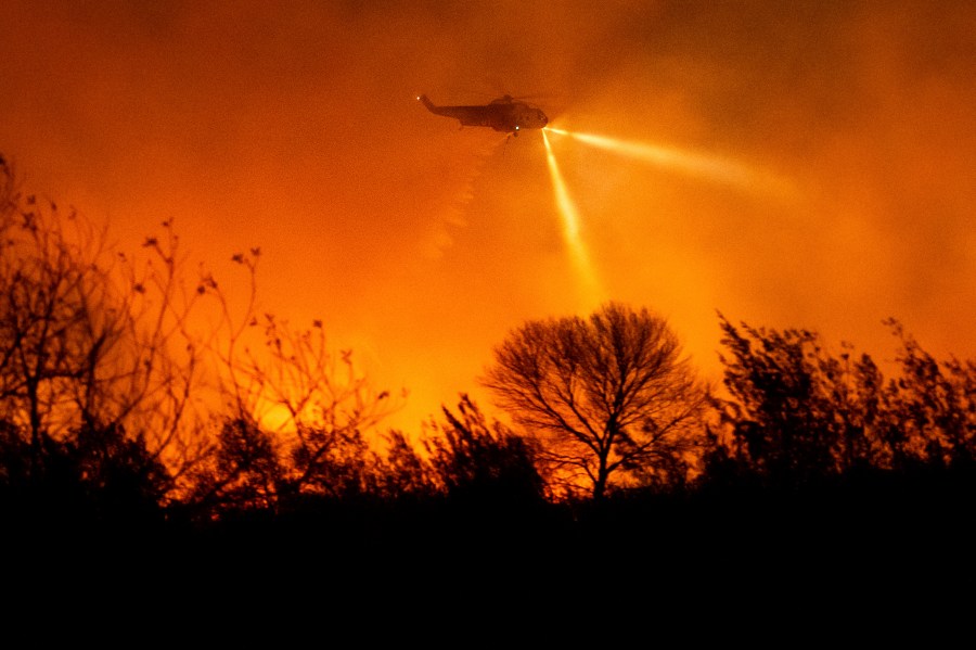 A helicopter drops water while fighting the Auto Fire in Ventura County, Calif., on Monday, Jan. 13, 2025. (AP Photo/Noah Berger)