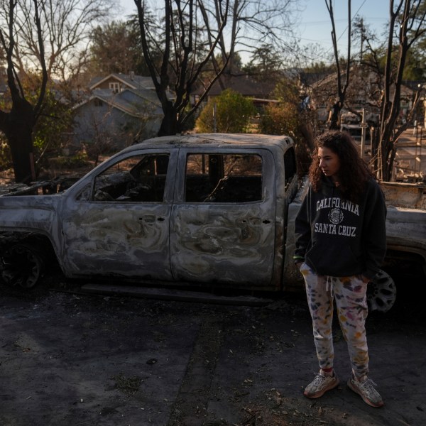 Kaylin Johnson, whose home is one of the few that survived the Eaton Fire in her neighborhood in Altadena, Calif., visits her neighbor's home Tuesday, Jan. 14, 2025. (AP Photo/Jae C. Hong)