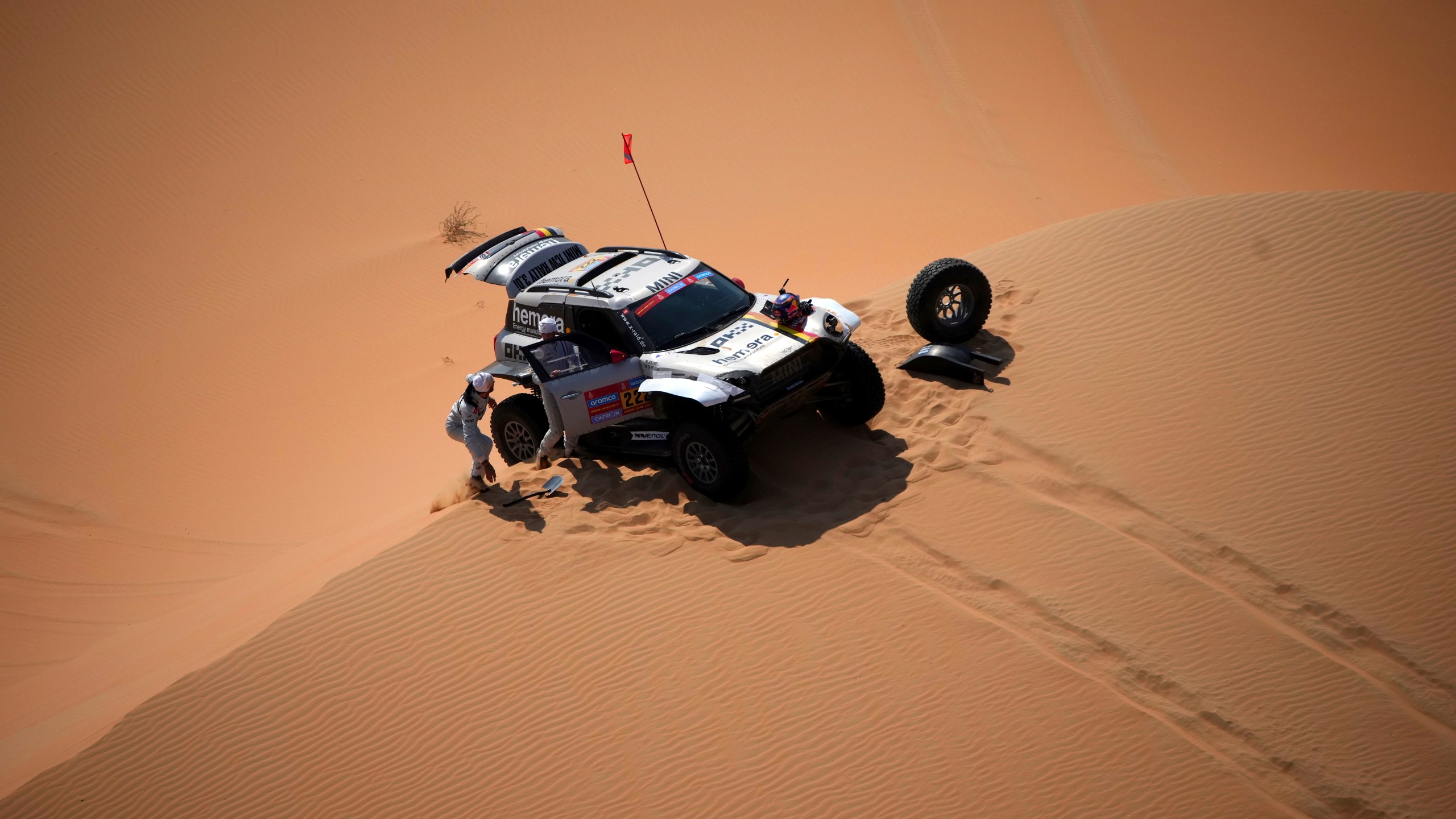 Driver Guillaume De Mevius and co-driver Mathieu Baumel repair a wheel during the tenth stage of the Dakar Rally between Haradh and Shubaytah, Saudi Arabia, Wednesday, Jan. 15, 2025. (AP Photo/Christophe Ena)