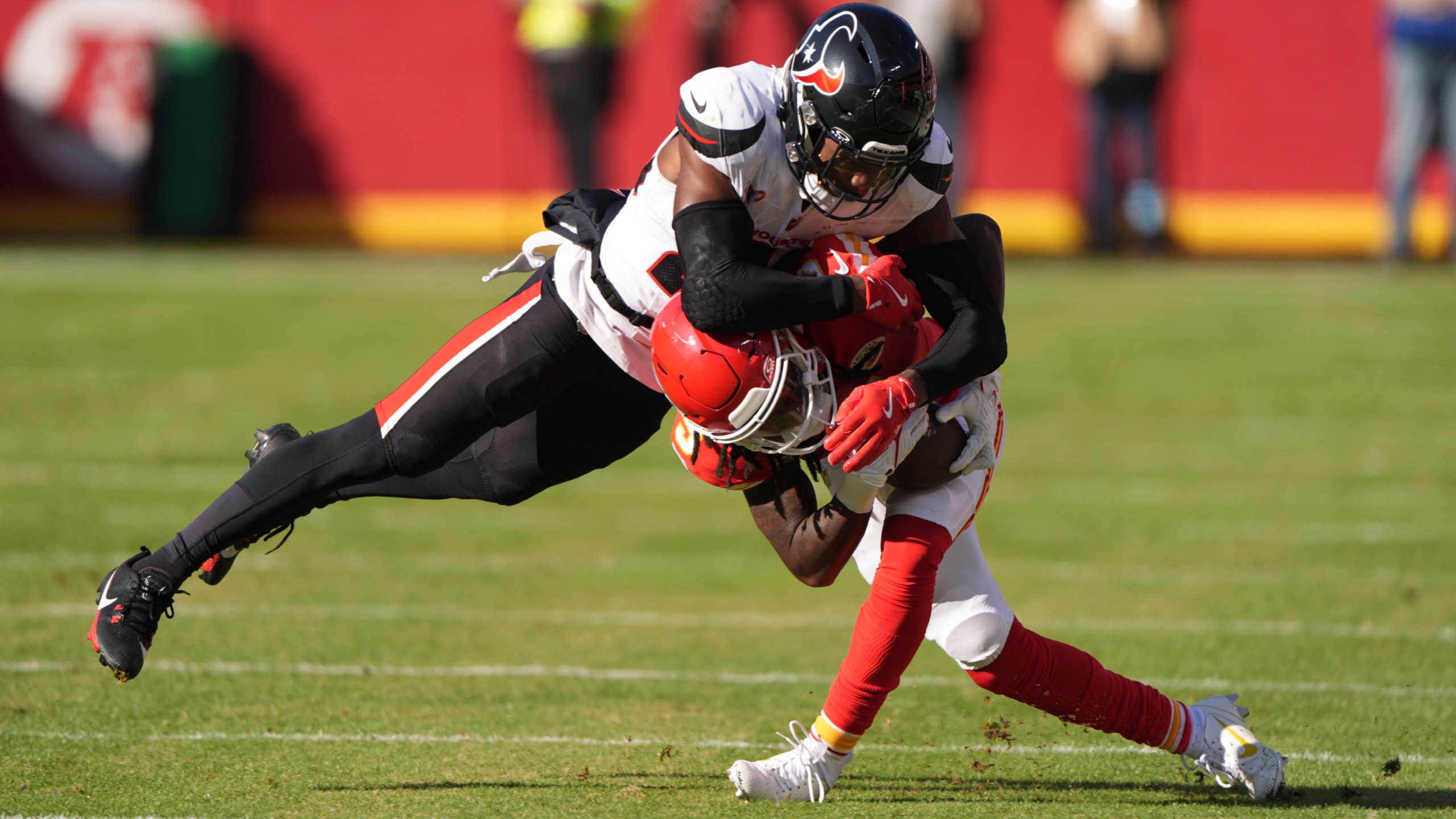 Kansas City Chiefs wide receiver Hollywood Brown is tackled by Houston Texans safety Eric Murray, left, during the first half of an NFL football game Saturday, Dec. 21, 2024, in Kansas City, Mo. (AP Photo/Charlie Riedel)