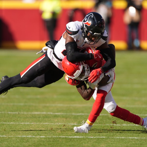 Kansas City Chiefs wide receiver Hollywood Brown is tackled by Houston Texans safety Eric Murray, left, during the first half of an NFL football game Saturday, Dec. 21, 2024, in Kansas City, Mo. (AP Photo/Charlie Riedel)