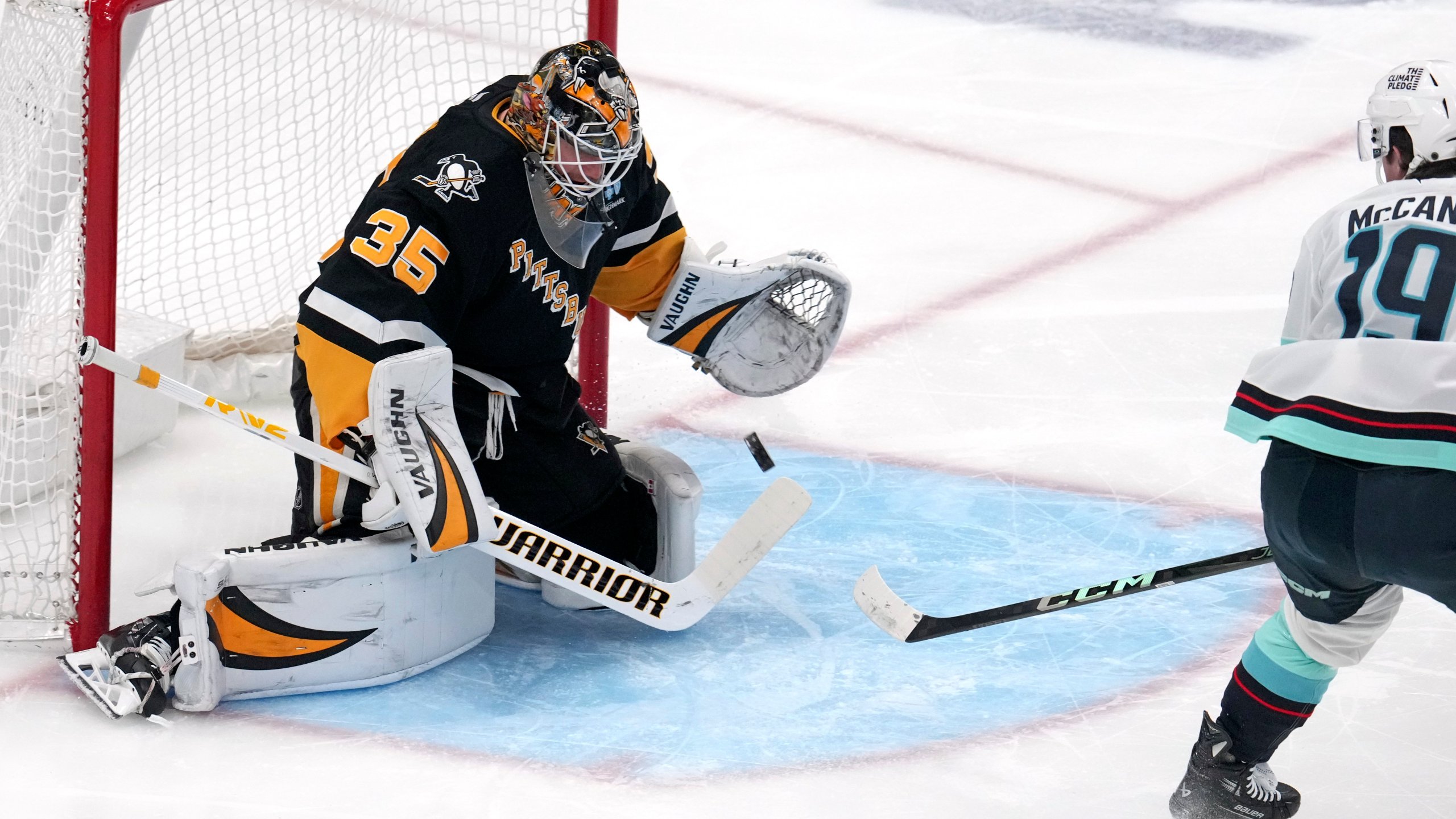 Pittsburgh Penguins goaltender Tristan Jarry blocks a shot by Seattle Kraken's Jared McCann during the first period of an NHL hockey game in Pittsburgh, Tuesday, Jan. 14, 2025. (AP Photo/Gene J. Puskar)