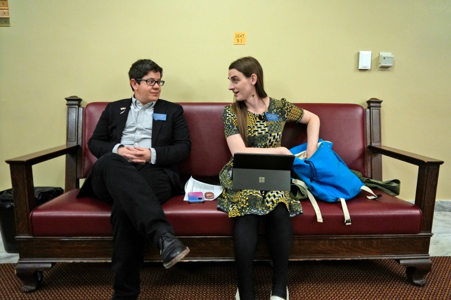 FILE - State Rep. Zooey Zephyr, right, speaks with colleague Rep. SJ Howell after House Speaker Matt Regier told her she could not work from the hallway just outside the main chamber of the House, April 27, 2023 in Helena, Mont. (AP Photo/Brittany Peterson, File)