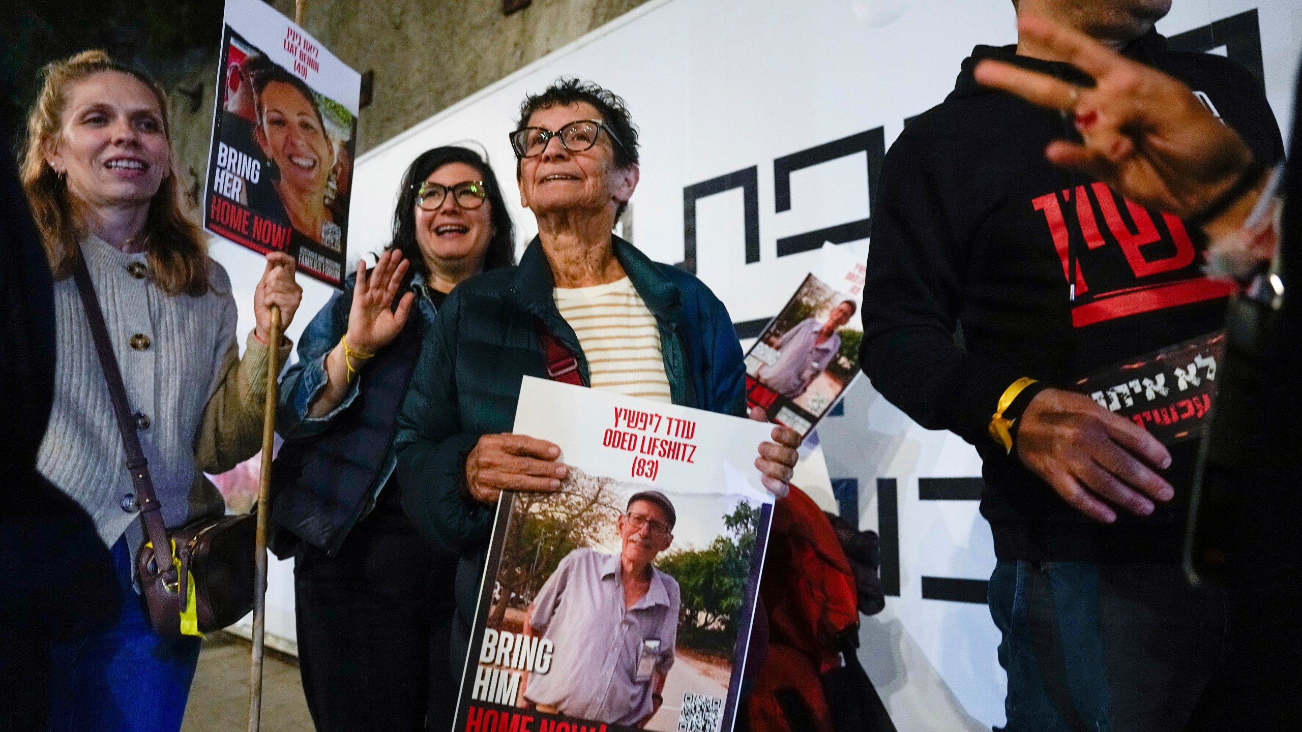 FILE - Yocheved Lifshitz, 85, center, a former hostage who was released from captivity by Hamas last month, holds a photo of her husband, Oded Lifshitz, during a protest calling for the release of hostages still held in the Gaza Strip, in Tel Aviv, Israel, Nov. 28, 2023. (AP Photo/Ariel Schalit, File)