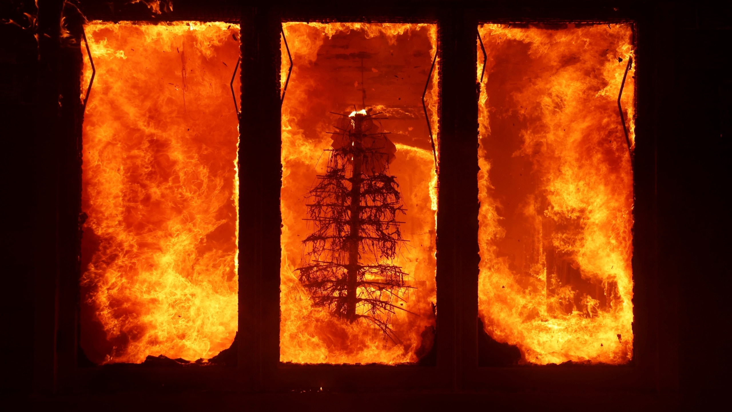 FILE - The Palisades Fire burns a Christmas tree inside a residence in the Pacific Palisades neighborhood of Los Angeles, Tuesday, Jan. 7, 2025. (AP Photo/Ethan Swope, File)