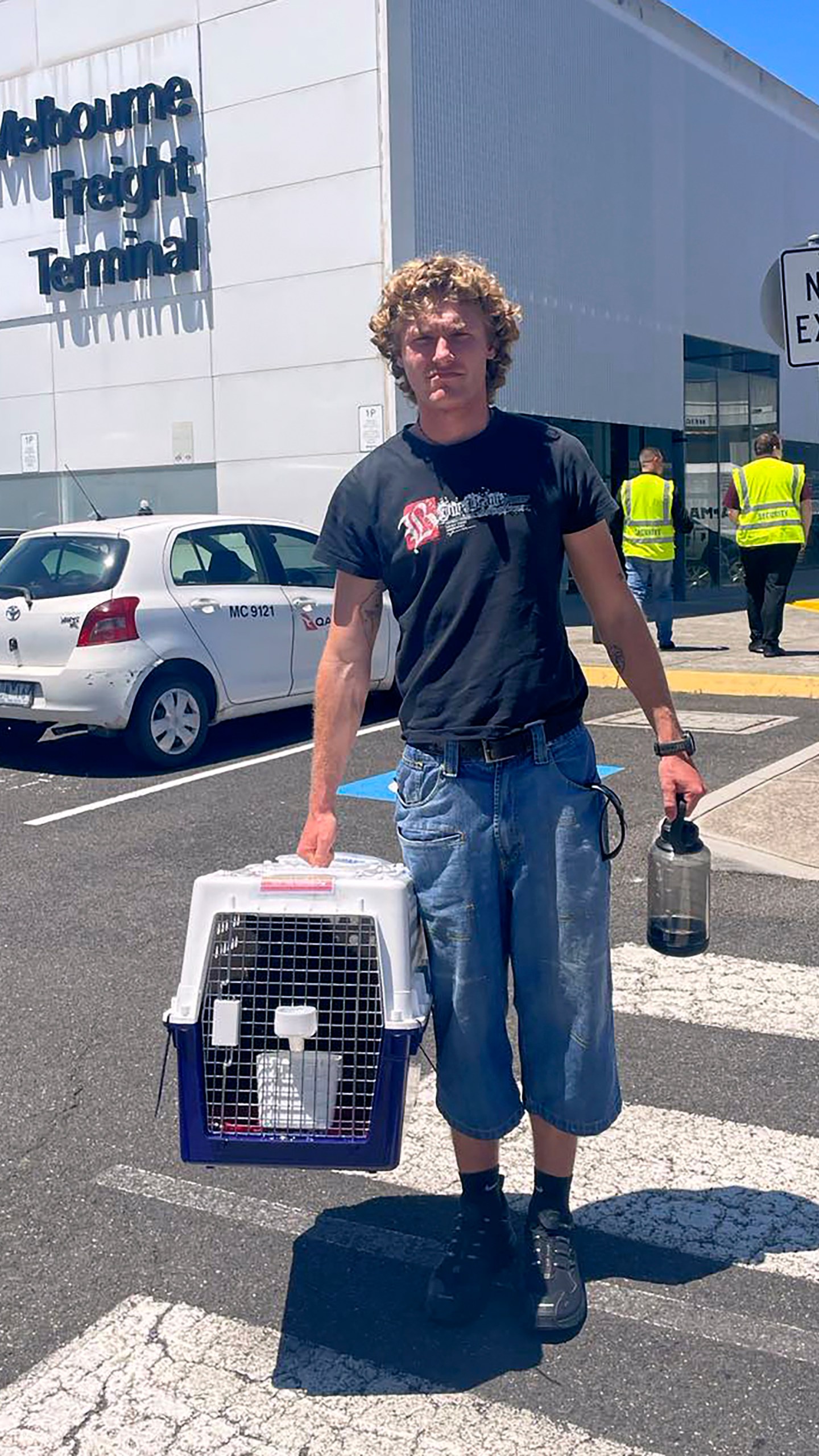 In this photo provided by Margo Neas, her son Jackson Brow holds their cat, Mittens, in a cat carrier at Melbourne Airport on Jan. 14, 2025. (Margo Neas via AP)