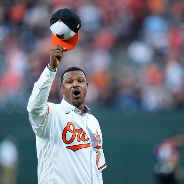 FILE - Former Baltimore Orioles player Adam Jones raises his cap on the field during a pregame ceremony, Sept. 15, 2023, in Baltimore. (AP Photo/Julio Cortez, file)