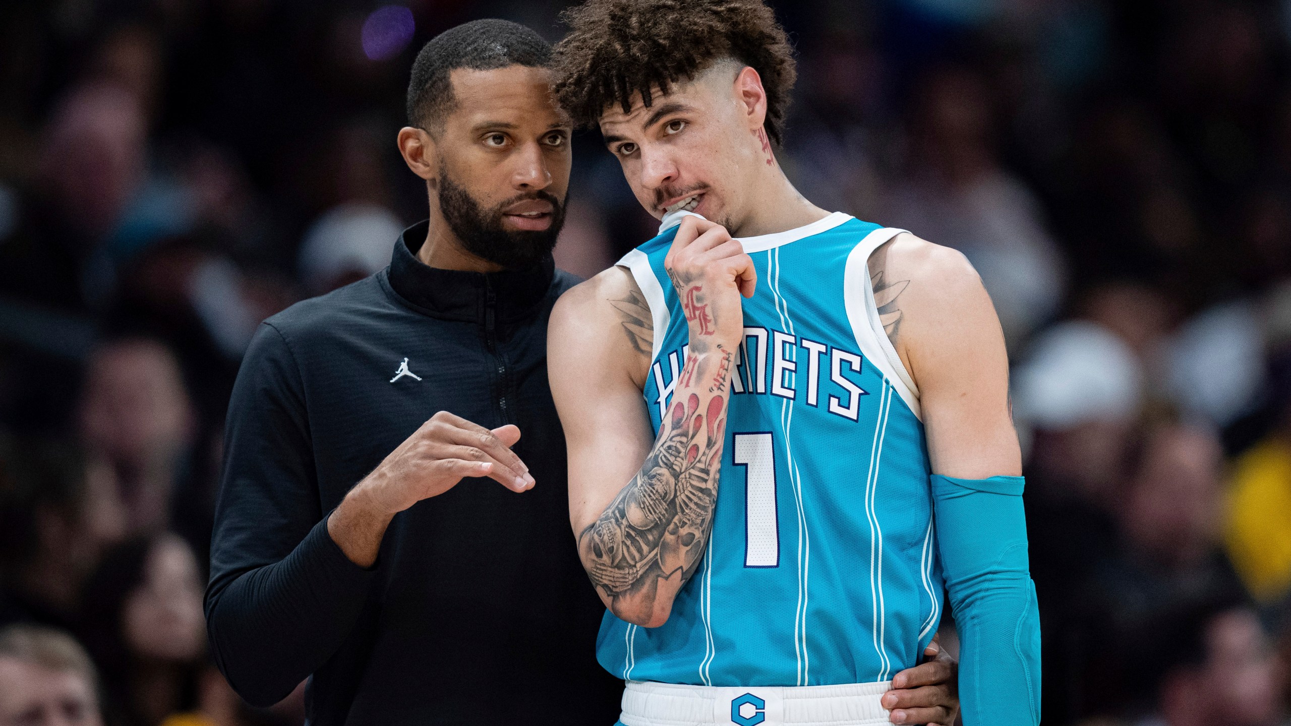 Charlotte Hornets head coach Charles Lee, left, talks with guard LaMelo Ball (1) during the first half of an NBA basketball game against the Los Angeles Lakers, Monday, Jan. 27, 2025, in Charlotte, N.C. (AP Photo/Jacob Kupferman)