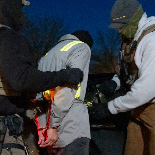 U.S. Immigration and Customs Enforcement officers use a chain to more comfortably restrain a detained person using handcuffs positioned in front, Monday, Jan. 27, 2025, in Silver Spring, Md. (AP Photo/Alex Brandon)