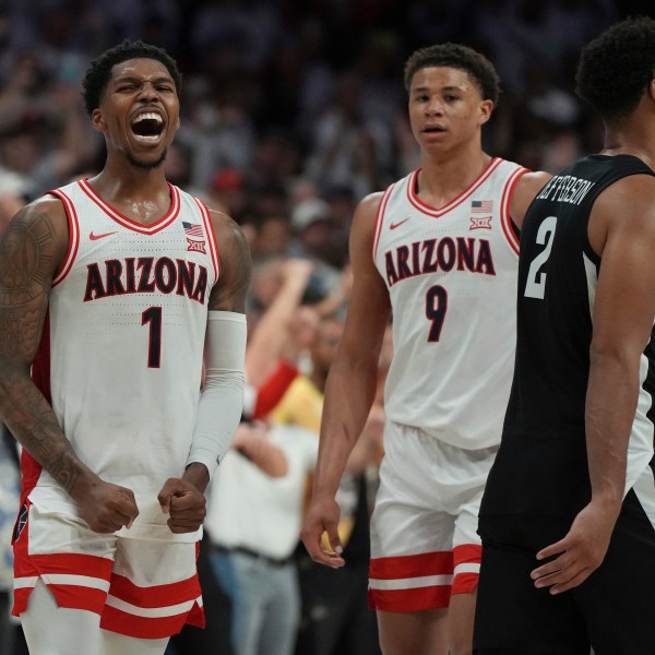 Arizona guard Caleb Love (1) and forward Carter Bryant (9) celebrate after defeating Iowa State in overtime in an NCAA college basketball game, Monday, Jan. 27, 2025, in Tucson, Ariz. (AP Photo/Rick Scuteri)