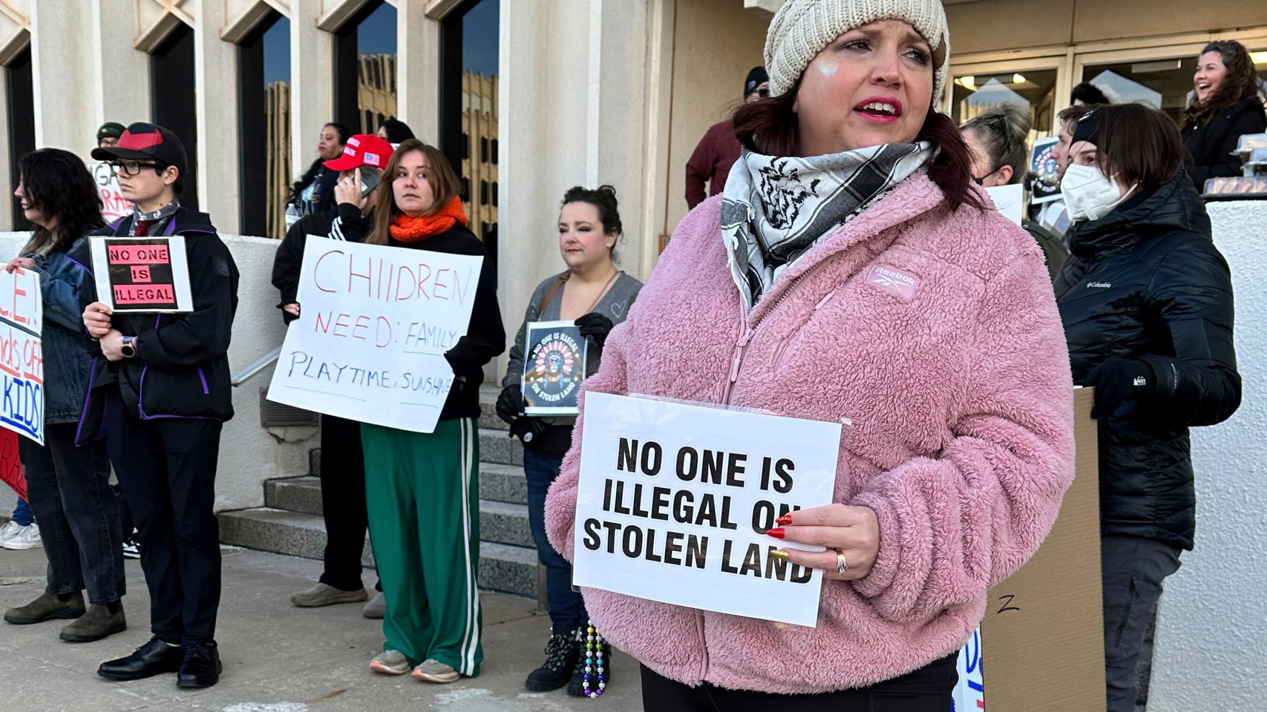 Erica Watkins of Tulsa, state director of Defense of Democracy holds a sign to protest Oklahoma's Board of Education considering a rule that would require parents enrolling children in public schools to provide proof of their child's U.S. citizenship or legal immigration status on Tuesday, Jan. 28, 2025 in Oklahoma City. (AP Photo/Sean Murphy)