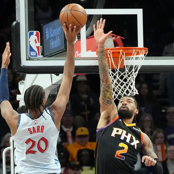 Washington Wizards forward Alex Sarr (20) tries to shoot over Phoenix Suns center Nick Richards (2) during the second half of an NBA basketball game Saturday, Jan. 25, 2025, in Phoenix. (AP Photo/Ross D. Franklin)