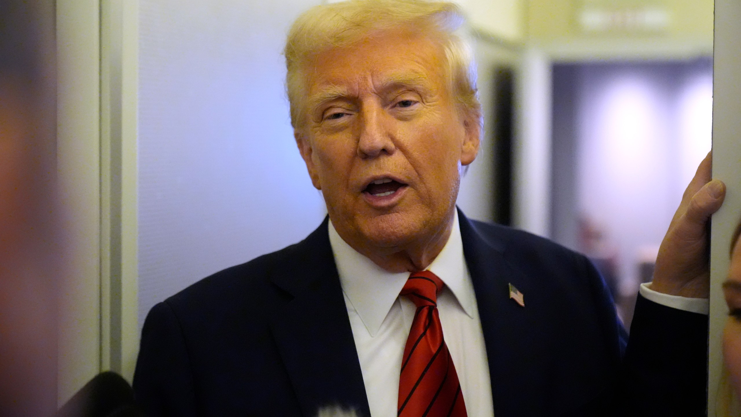 President Donald Trump speaks to reporters aboard Air Force One en route from Miami to Joint Base Andrews, Md., Monday, Jan. 27, 2025. (AP Photo/Mark Schiefelbein)