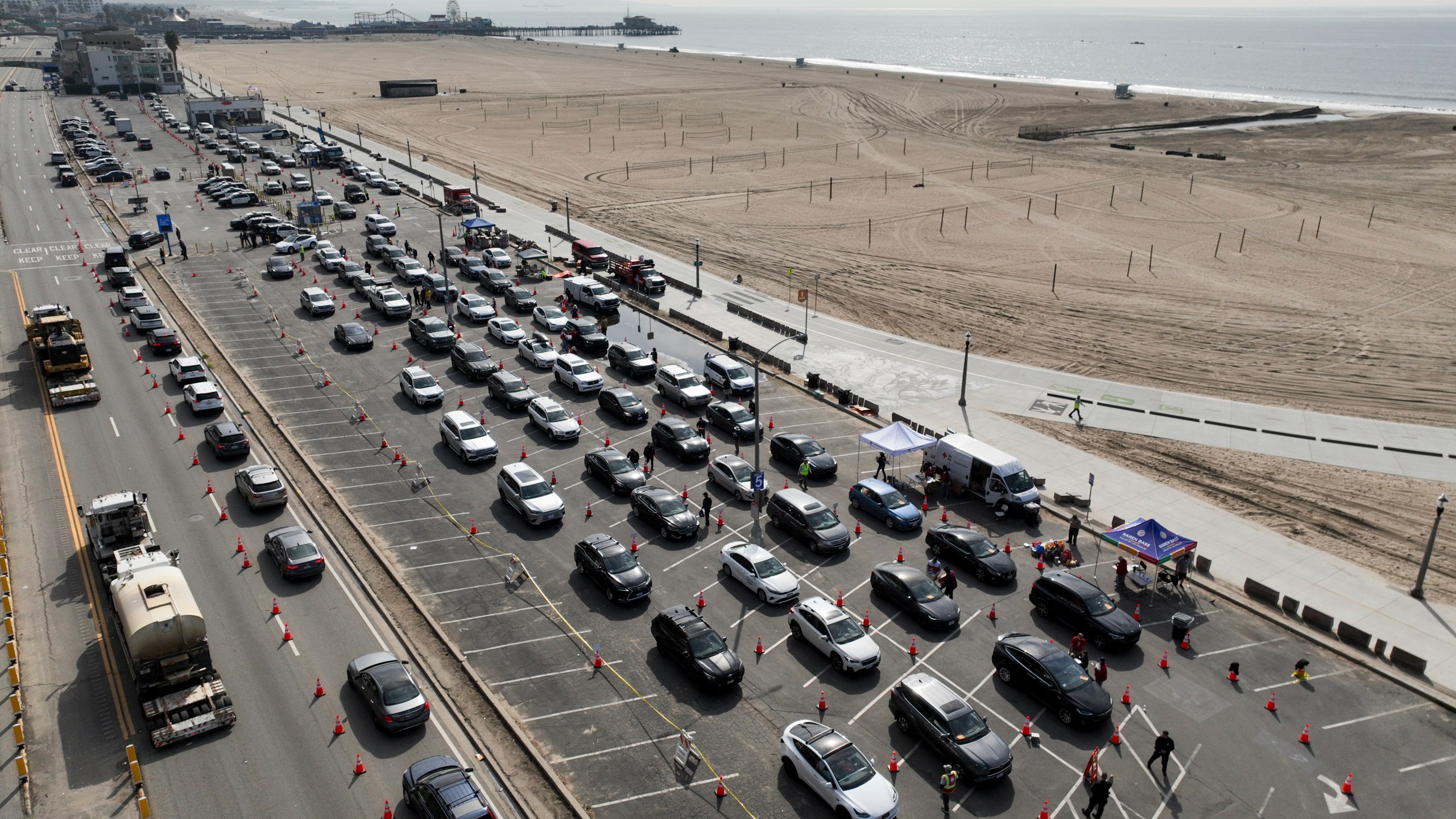 Motorists form a queue in a parking lot and along Pacific Coast Highway waiting to enter the Palisades Fire zone Tuesday, Jan. 28, 2025 in Santa Monica, Calif. (AP Photo/Jae C. Hong)